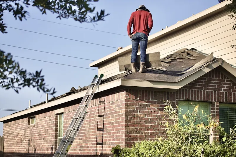 Professional roofer working on a residential roof in Estates at Tall Oaks